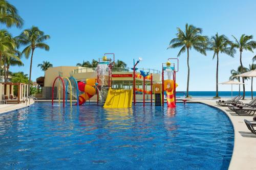 - une piscine dans un complexe avec un parc aquatique dans l'établissement Dreams Riviera Cancun Resort & Spa - All Inclusive, à Puerto Morelos