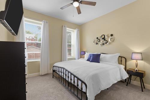 a bedroom with a bed and a ceiling fan at Chic 4-Bed Home near Attractions - JZ Vacation Rentals in Soulard