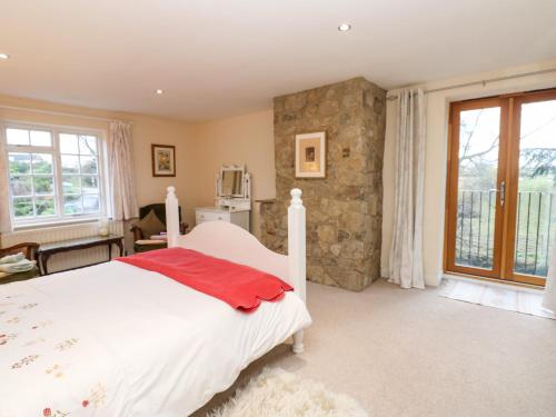 a bedroom with a white bed and a stone wall at Malt Shovel Cottage in Bedale