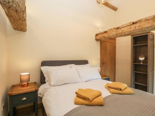 a bedroom with a bed with two towels on it at Chequers Barn in Corsham