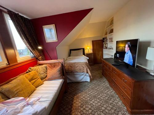 a hotel room with a bed and a tv and a couch at Ramadale B&B in Stornoway