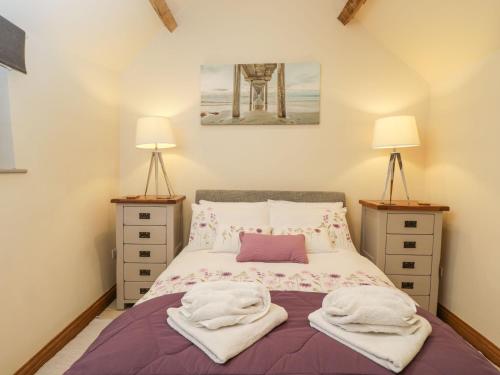 a bedroom with a bed with towels on it at The Cattle Byre in Corsham