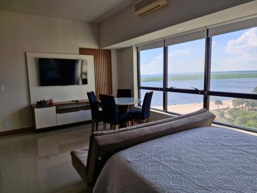 1 dormitorio con 1 cama, mesa y sillas en Hotel Tropical Executive Flat 020 en Manaos