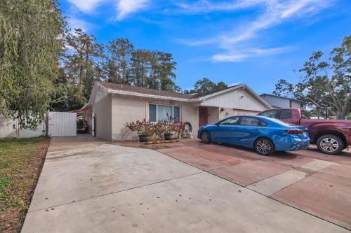 a house with a blue car parked in a driveway at Tampa Tranquility - Chic Retreat condo in Tampa