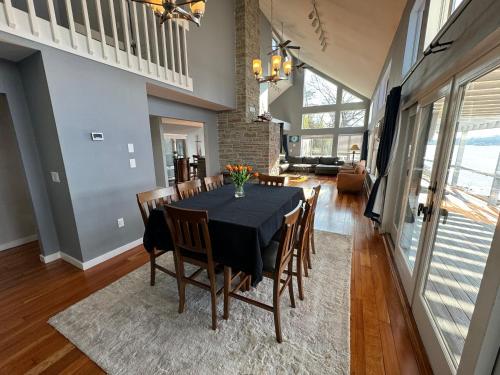 a dining room with a black table and chairs at Spectacular home with a amazing ocean - river view in Groton