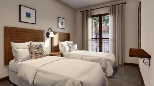 um quarto de hotel com duas camas e uma janela em Quinta Santa Bárbara em Pirenópolis