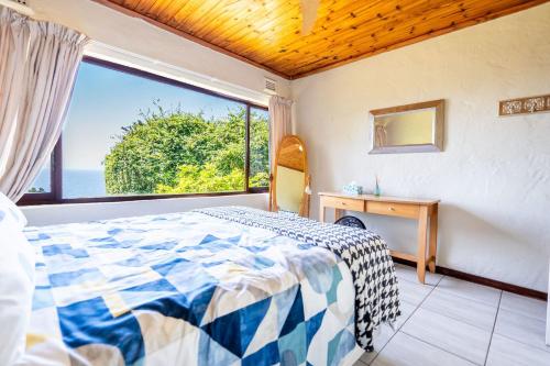 ウムドロティにあるHilltop Hideawayのベッドと大きな窓のある寝室
