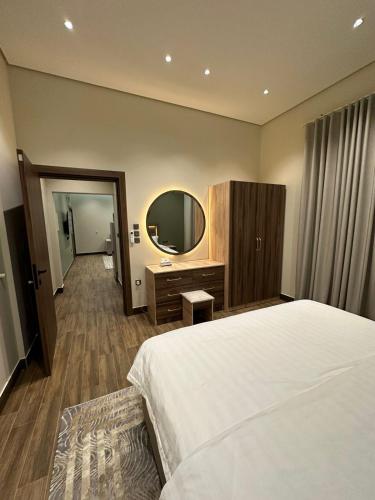 a hotel room with a bed and a mirror at سكن التميز للإيجار (وحدات سكنية مفروشة) in Al-Salam