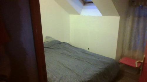 ein Schlafzimmer mit einem Bett in einem kleinen Zimmer in der Unterkunft Chambre dans maison in Betton