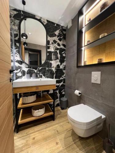 a bathroom with a white toilet and a mirror at MODERN MOUNTAIN II in Kolašin