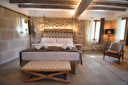 a bedroom with a large bed and a chair at Calvario Plaza Hotel in Pollença