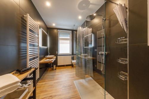 La salle de bains est pourvue d'une douche et d'une cabine de douche en verre. dans l'établissement Ferienhaus Bavaria WR - Ferienwohnung Servus, à Wernigerode