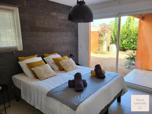 - une chambre avec un lit et des chaussons dans l'établissement Villa Lolotte - Lecci, à Lecci