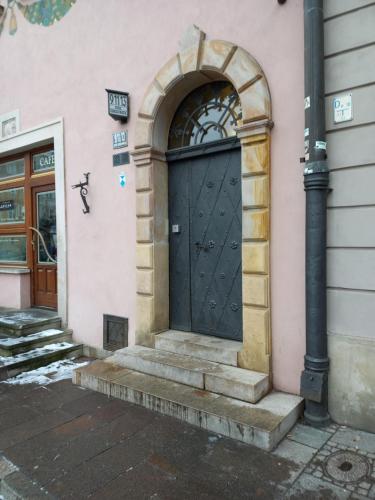 uma porta preta ao lado de um edifício rosa em Apartamenty - MI Stare Miasto em Varsóvia