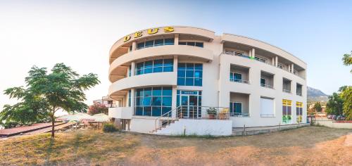 a large white building with a sign on it at Apartments Deus in Dobra Voda