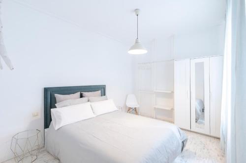 een witte slaapkamer met een groot wit bed met witte kussens bij Nordic apartment Sagrada Familia in Barcelona