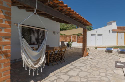 a patio with a hammock hanging from a house at Country House - Quinta das 3 Nogueiras in Abitureiras