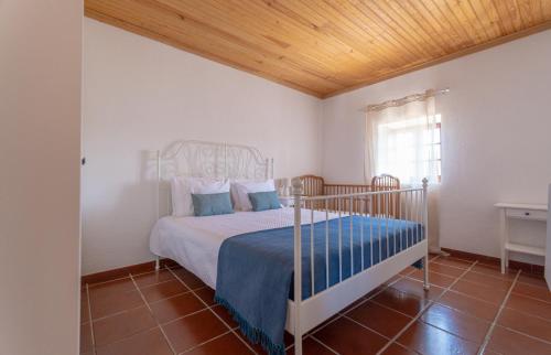 a bedroom with a bed with a wooden ceiling at Country House - Quinta das 3 Nogueiras in Abitureiras