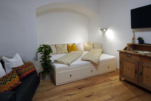 a white couch with pillows in a living room at Altstadt Apartment am Schergentor in Hall in Tirol