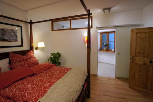 a bedroom with a bed and a window and a door at Altstadt Apartment am Schergentor in Hall in Tirol