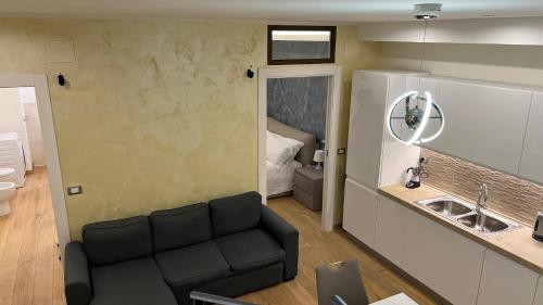 uma sala de estar com um sofá ao lado de uma cozinha em Loft San Leopardo em Rieti