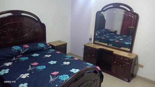 1 dormitorio con 1 cama con tocador y espejo en شقة مصيفية للايجار, en Alejandría