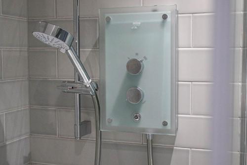a shower with a shower head in a bathroom at Finnieston Apartment in Glasgow