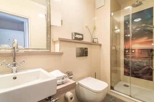 a bathroom with a sink and a toilet and a shower at Suiten-Hotel mare Langeoog in Langeoog