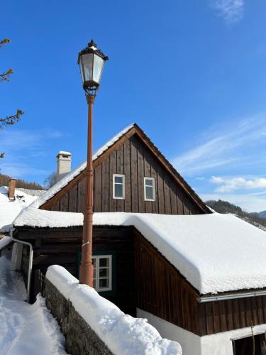 una casa en la nieve con luz de la calle en Santova roubenka, en Štramberk