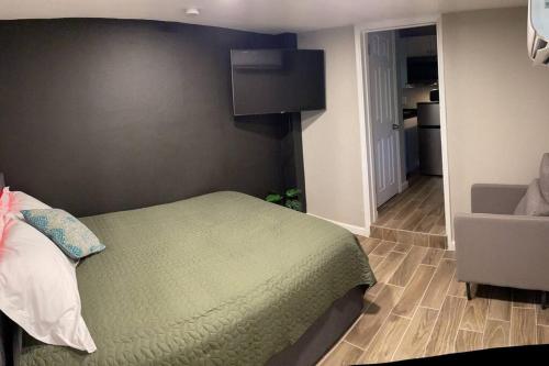 Schlafzimmer mit einem Bett und einem TV an der Wand in der Unterkunft New Midtown Studio with Full Kitchen (Unit C) in Phoenix
