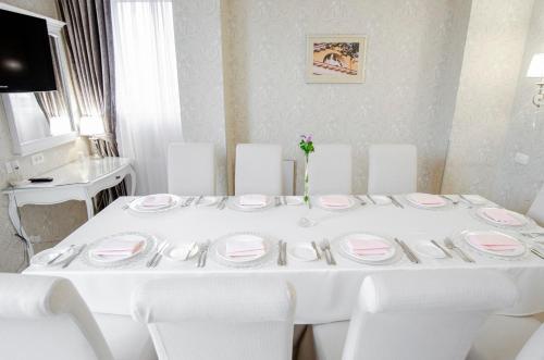 a white table with white chairs and plates on it at Swiss Hotel in Lviv