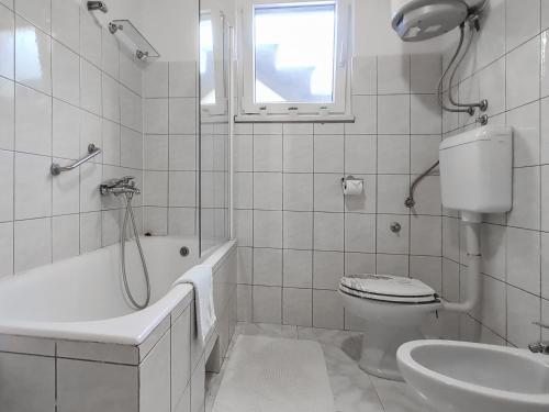 a white bathroom with a toilet and a sink at Sea-view Apartments Klara - Viganj in Viganj