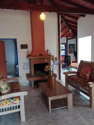 a living room with couches and a fireplace at Génesis, un lugar para descansar y disfrutar in Santa Elena