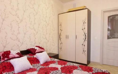um quarto com uma cama com almofadas vermelhas e brancas em VIP apart 610 em Tbilisi