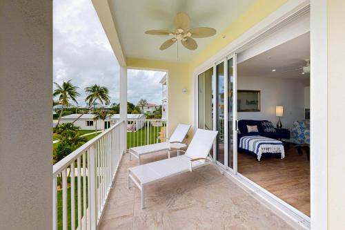 a living room with a ceiling fan and a balcony at Beach Club Tidal Wave #25 in Key Colony Beach