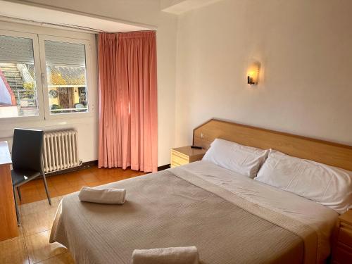 um quarto com uma cama, uma secretária e uma janela em Can Setmanes by CozyCatalonia em Blanes