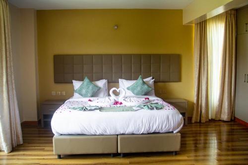 een slaapkamer met een groot wit bed met bloemen erop bij SpringWells Hotel ltd in Maua