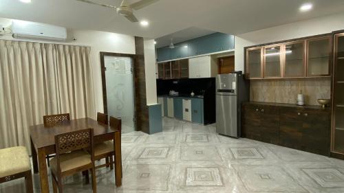 a large kitchen with a table and a refrigerator at Ahasa Bacardi in Hyderabad