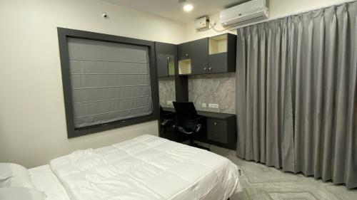 a bedroom with a bed and a desk and a window at Ahasa Bacardi in Hyderabad