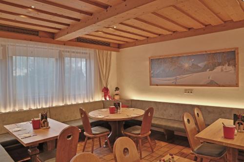 a restaurant with two tables and chairs and a couch at Hotel Moawirt in Wagrain