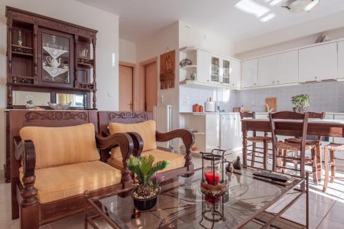 cocina y sala de estar con sofá y mesa en FANI ROXANE APARTMENTS, en Keratea