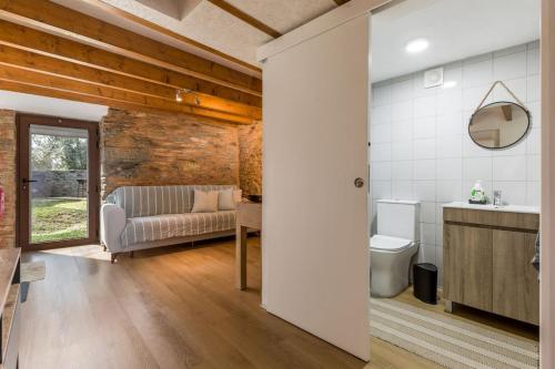 ein Wohnzimmer mit Couch und Toilette in der Unterkunft Casas de Xisto in Raiva
