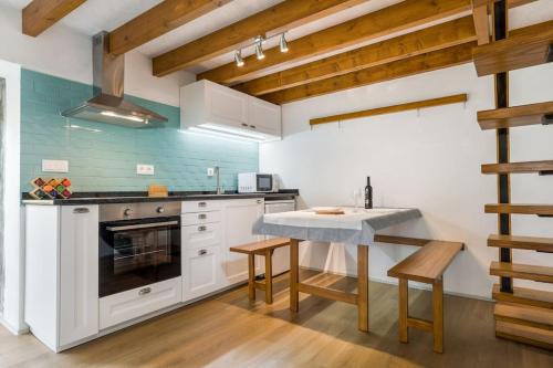 a kitchen with white cabinets and a table and chairs at Casas de Xisto in Raiva