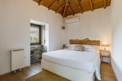 ein Schlafzimmer mit einem weißen Bett und einem Fenster in der Unterkunft Casas de Xisto in Raiva