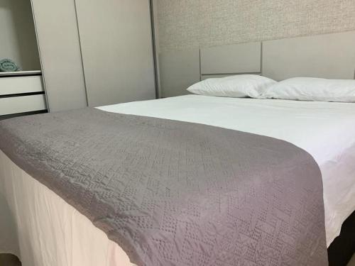 a bedroom with a bed with a blanket on it at Apartamento 2Q Próximo ao Albert Einstein EC1003 in Goiânia