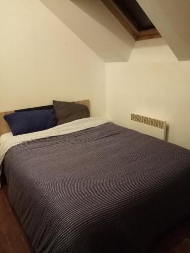 ein Schlafzimmer mit einem großen Bett in einem Zimmer in der Unterkunft Chambre dans maison in Betton