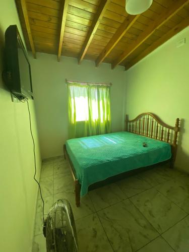 1 dormitorio con 1 cama y TV en Departamento Noa en Villa Gesell