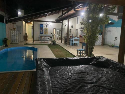 una casa con piscina por la noche en Casa Verão Nova Almeida, en Nova Almeida