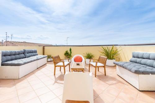 a patio with couches and chairs on a roof at Penthouse with Terrace in historic centre in Cagliari