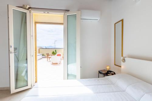 a bedroom with a white bed and a balcony at Penthouse with Terrace in historic centre in Cagliari